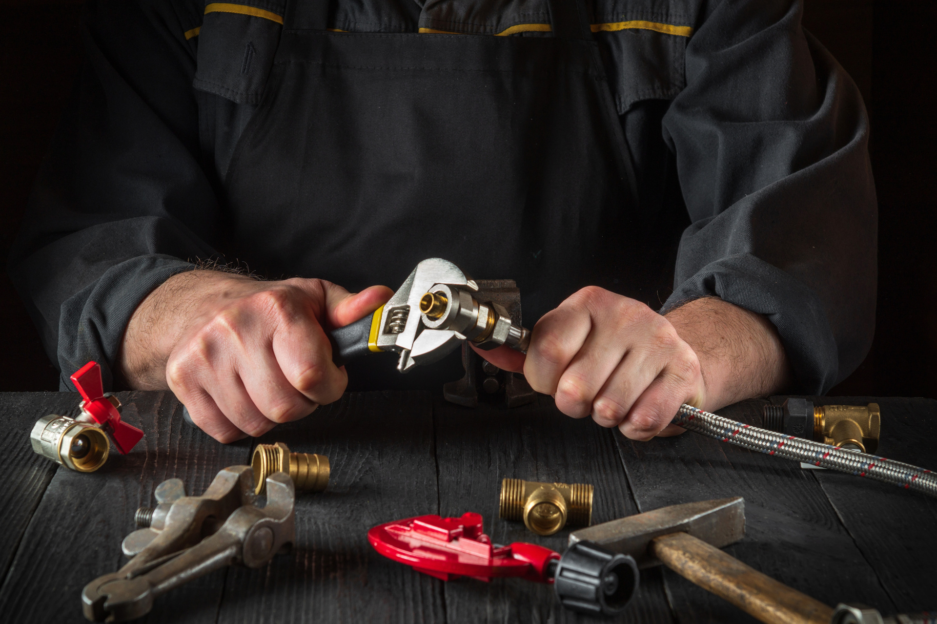 Plumber connects the brass fittings to the faucet with an adjust